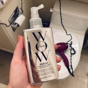 Two metallic Color Wow hair products: Dream Coat Supernatural Spray and Extra Mystical Shine Spray, displayed against a purple background.
