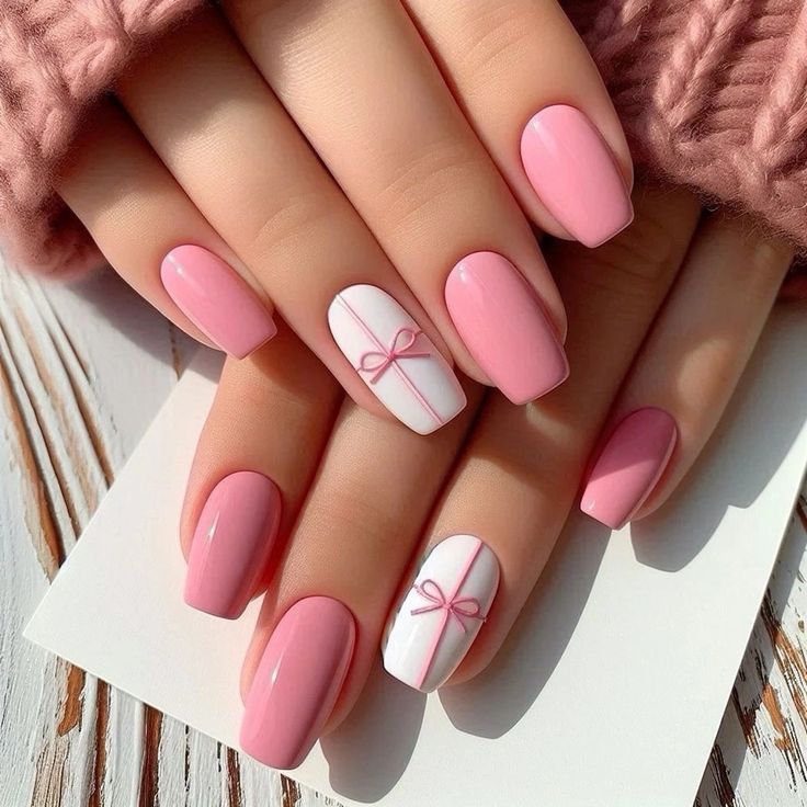Hands with glossy pink and white manicure featuring ribbon gift-wrap Short Nail Designs on accent fingers